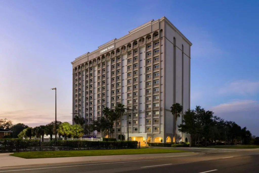 Crowne Plaza Orlando-Downtown hotel tower with palm trees and the street at dusk