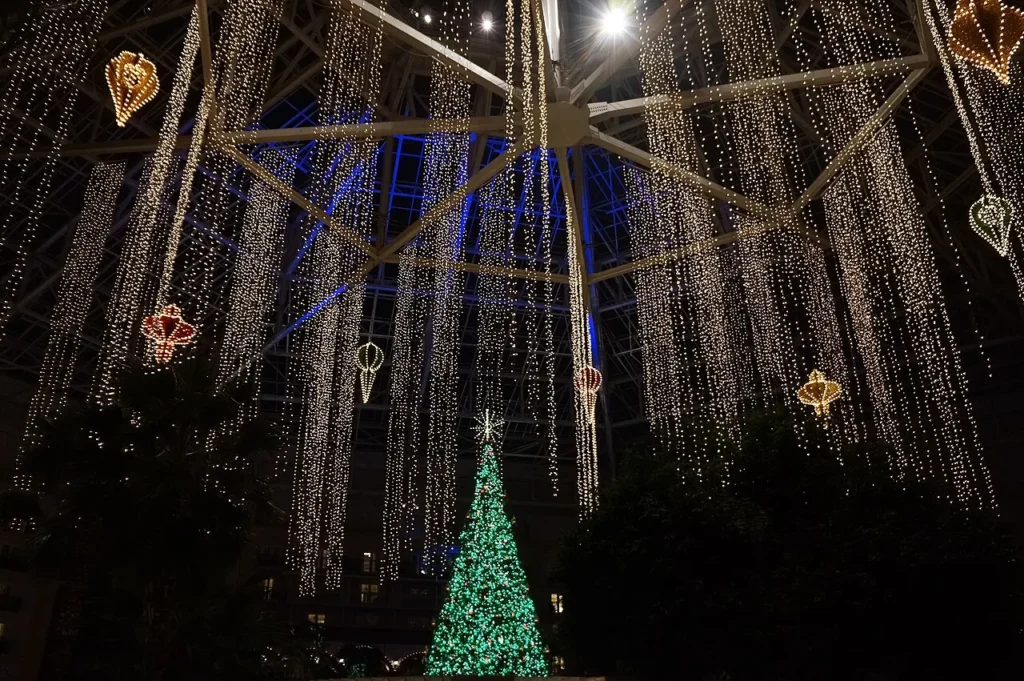 Curtains of white lights and a lit Christmas tree in the Gaylord Palms atrium at night