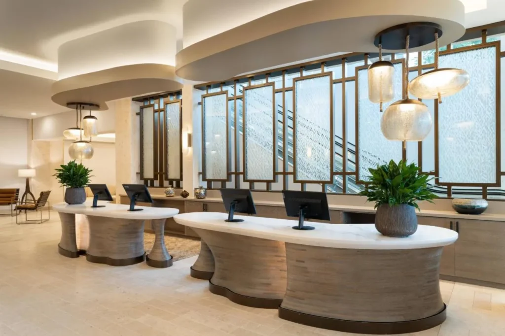 Curved check-in desks under glass pendant lights in the JW Marriott Orlando Bonnet Creek lobby