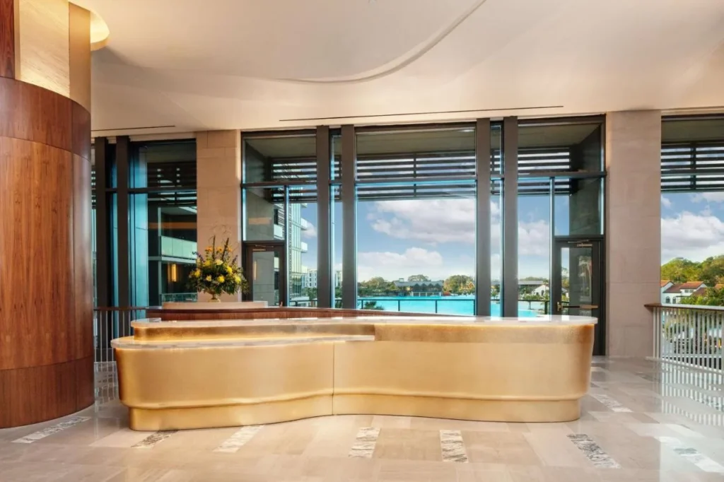 Recepci&oacute;n curva de oro en el vest&iacute;bulo Conrad Orlando con ventanas frente a Evermore Bay