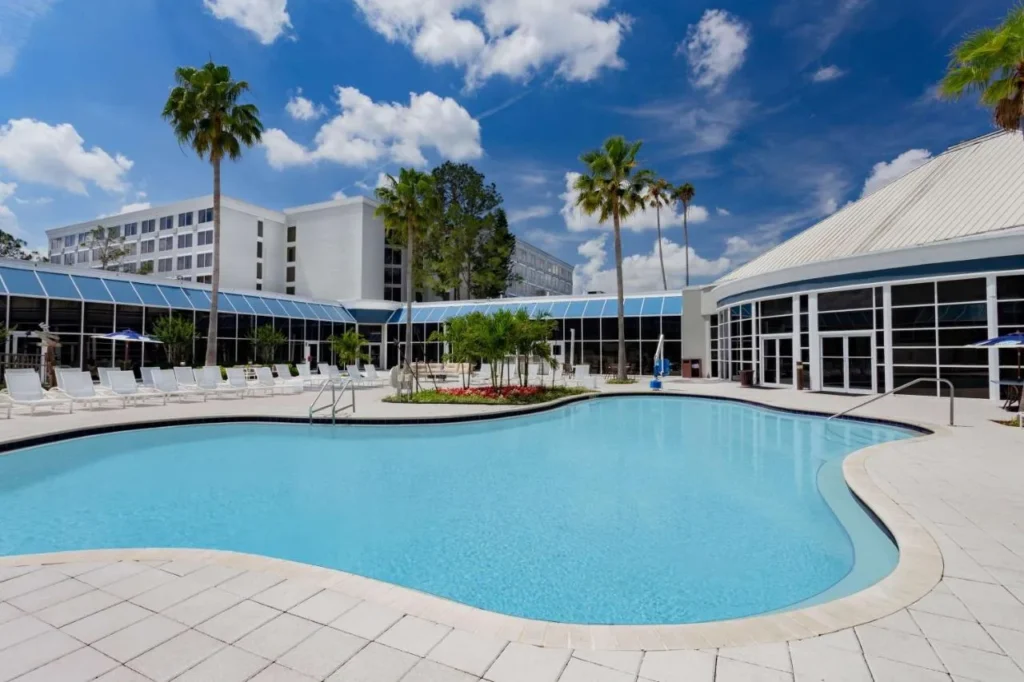 Piscina exterior curva y edificio con paredes de vidrio en el Holiday Inn Resort Kissimmee by the Parks