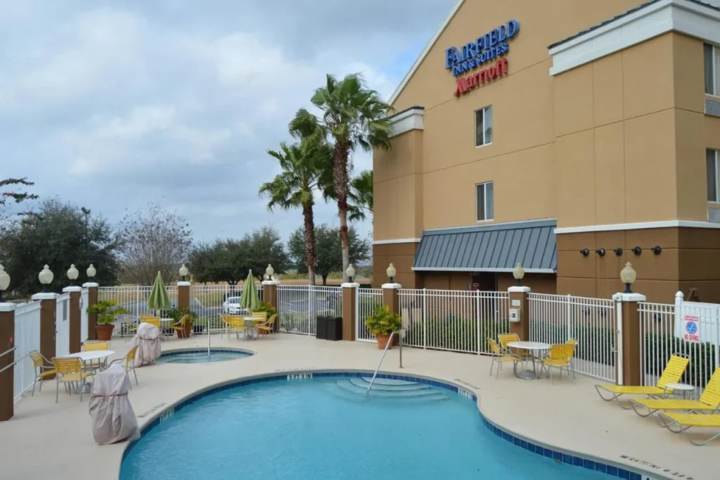 Curved outdoor pool and hot tub beside the Fairfield by Marriott Inn & Suites Clermont building