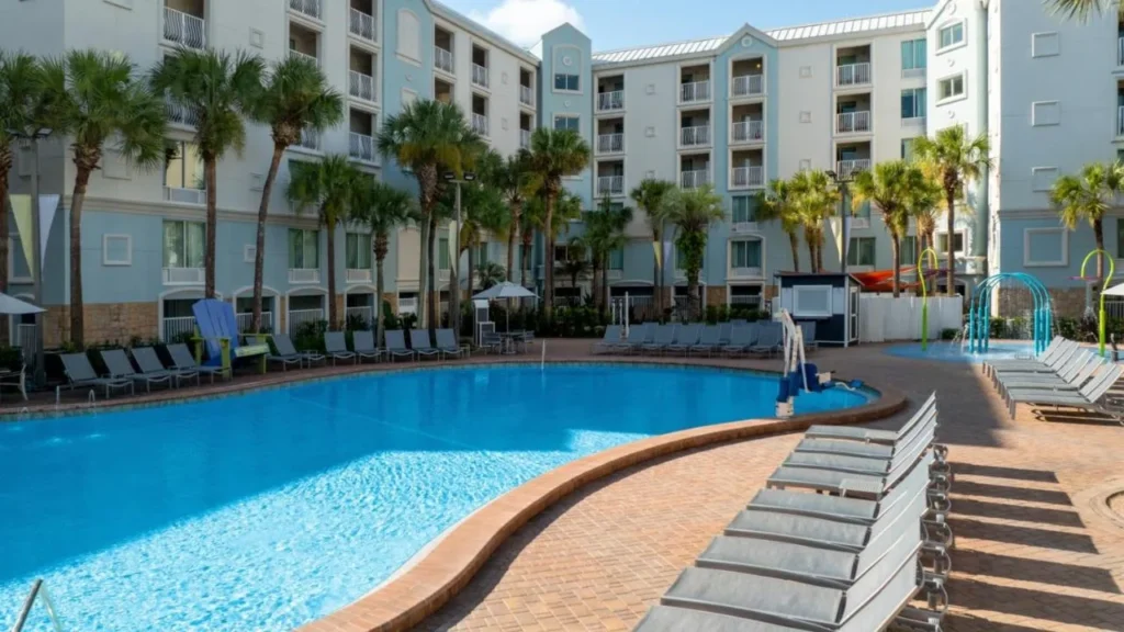 Curving outdoor pool with loungers and palm trees at Holiday Inn Resort Orlando Lake Buena Vista