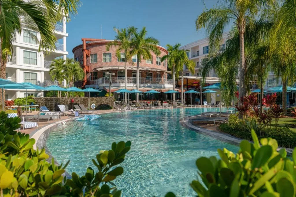 Piscina curva con palmeras y sombrillas azules en Meli&aacute; Orlando Celebration