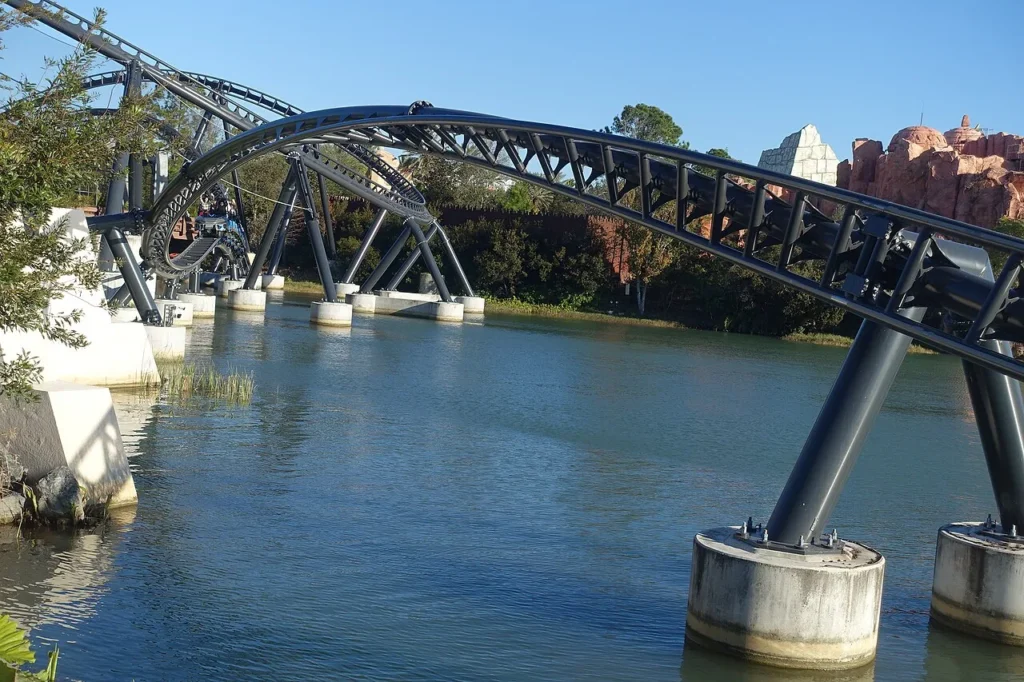 Dark Jurassic World VelociCoaster track arching over a lagoon at Universal Islands of Adventure