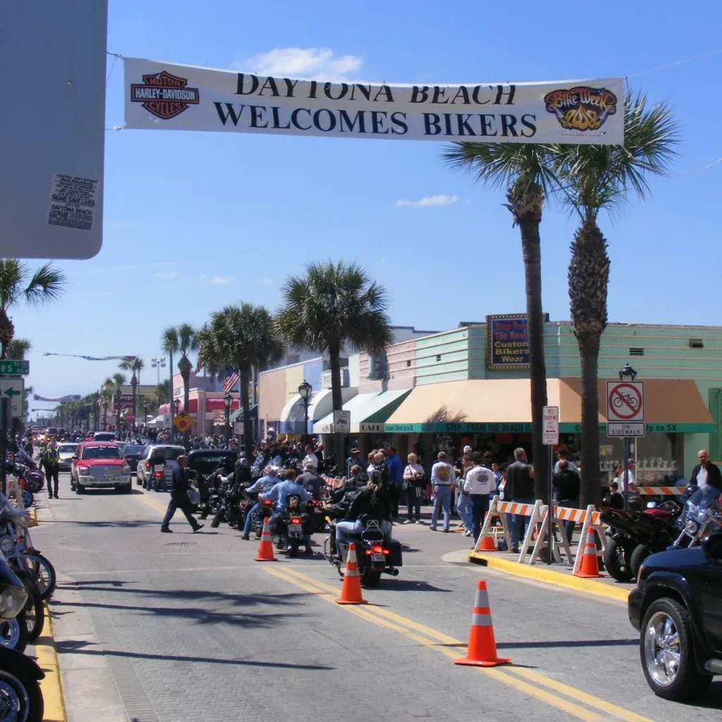 Daytona Beach Welcomes Bikers banner over Main Street with motorcycles and crowds during Daytona Bike Week