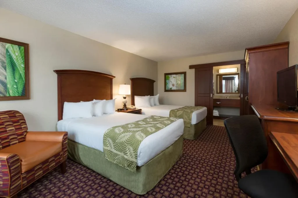 Habitaci&oacute;n Deluxe con dos camas dobles, sill&oacute;n y escritorio en Rosen Inn International on I-Drive