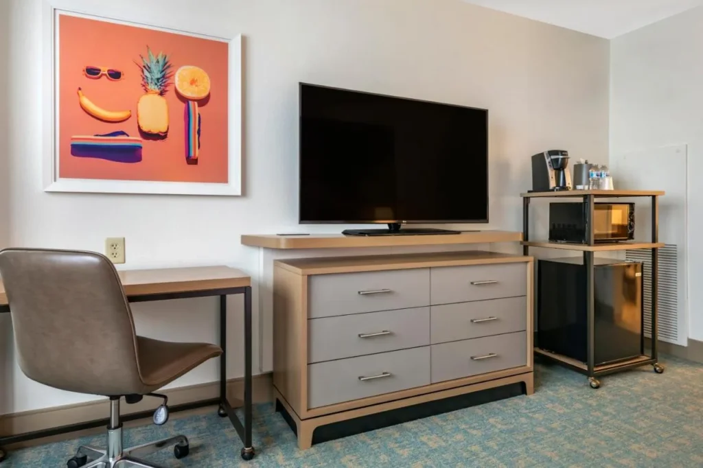 Escritorio, cómoda, TV y microondas en una habitación en Holiday Inn Orlando Disney Springs