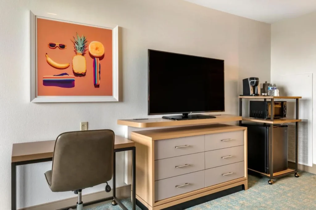 Desk, TV, microwave, mini-fridge and coffee maker in a room at Holiday Inn Orlando Disney Springs