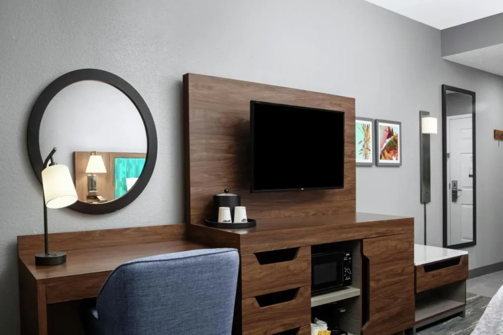 Desk, wall-mounted TV, coffee maker and microwave in a room at Hampton Inn Orlando/Lake Buena Vista
