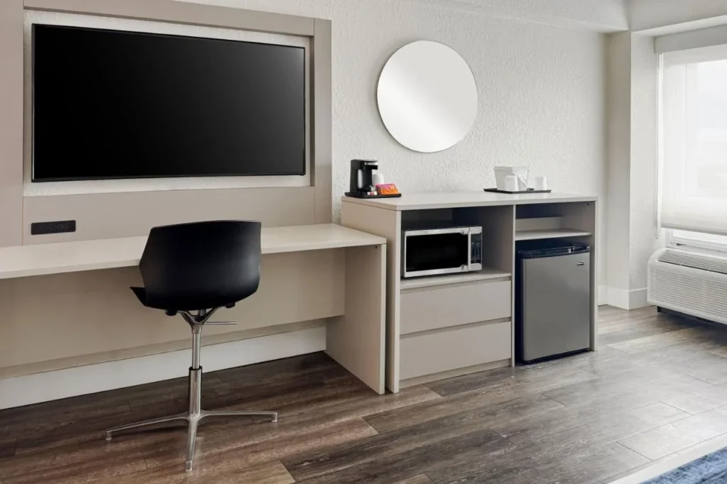 Desk, wall TV, microwave, mini-fridge and coffee maker in a room at Wyndham I-Drive Avanti