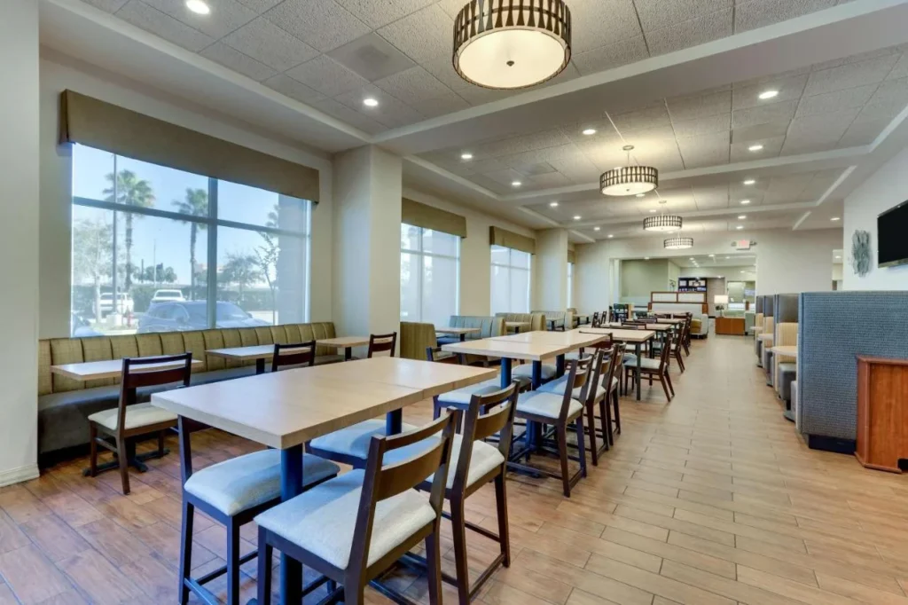Dining area with high tables and window booths at Drury Inn & Suites near Universal