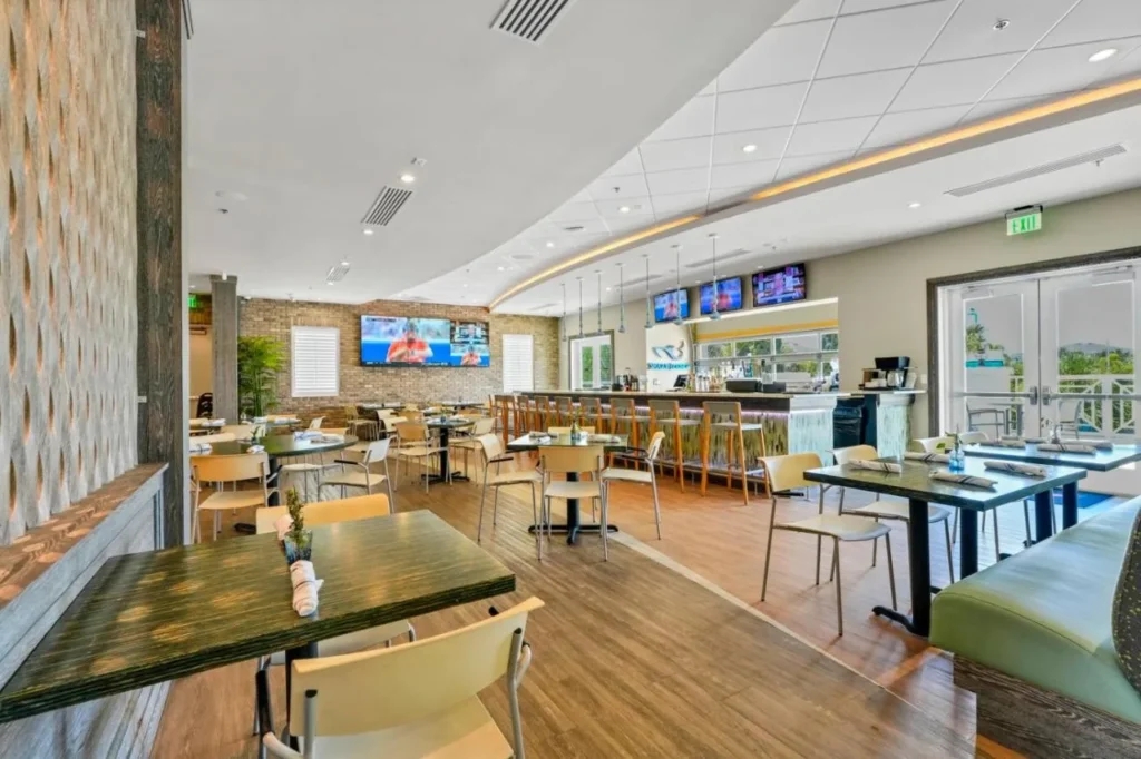 Dining room with tables, TVs and the Shark Lounge bar at Encore Resort at Reunion
