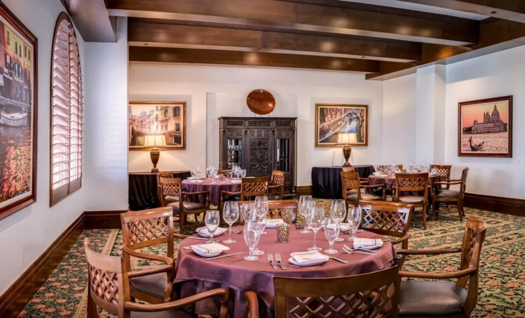Dining room with Venice paintings and set round tables at Rosen Shingle Creek