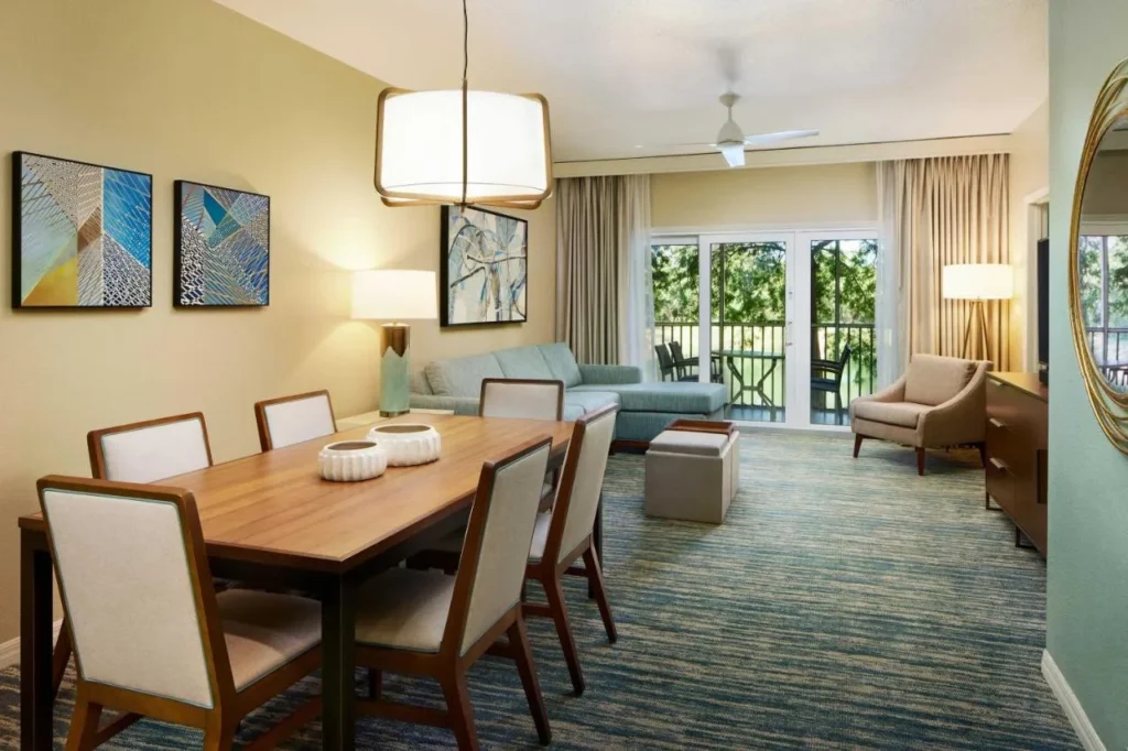 Mesa de comedor con seis sillas y sala de estar que se abre a un balcón en Sheraton Vistana Resort