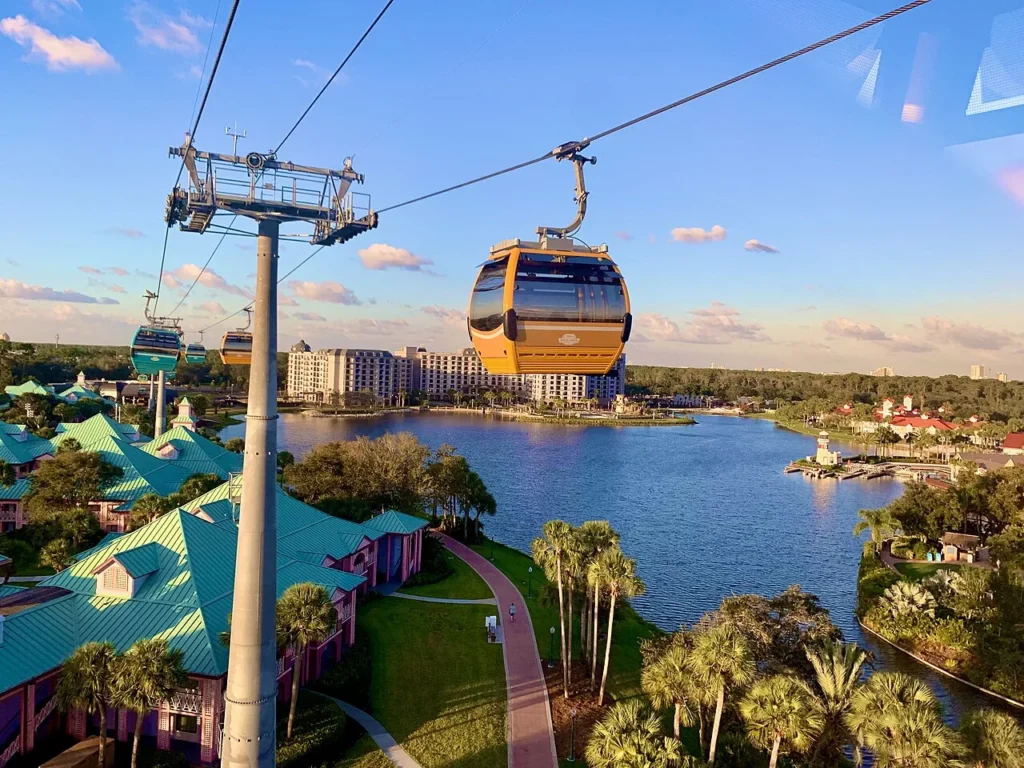 Góndola de Disney Skyliner sobre Caribbean Beach Resort con Riviera Resort al otro lado del lago