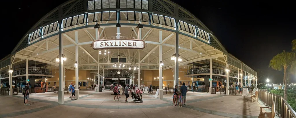 Disney Skyliner hub station at Disney's Caribbean Beach Resort lit up at night with gondolas