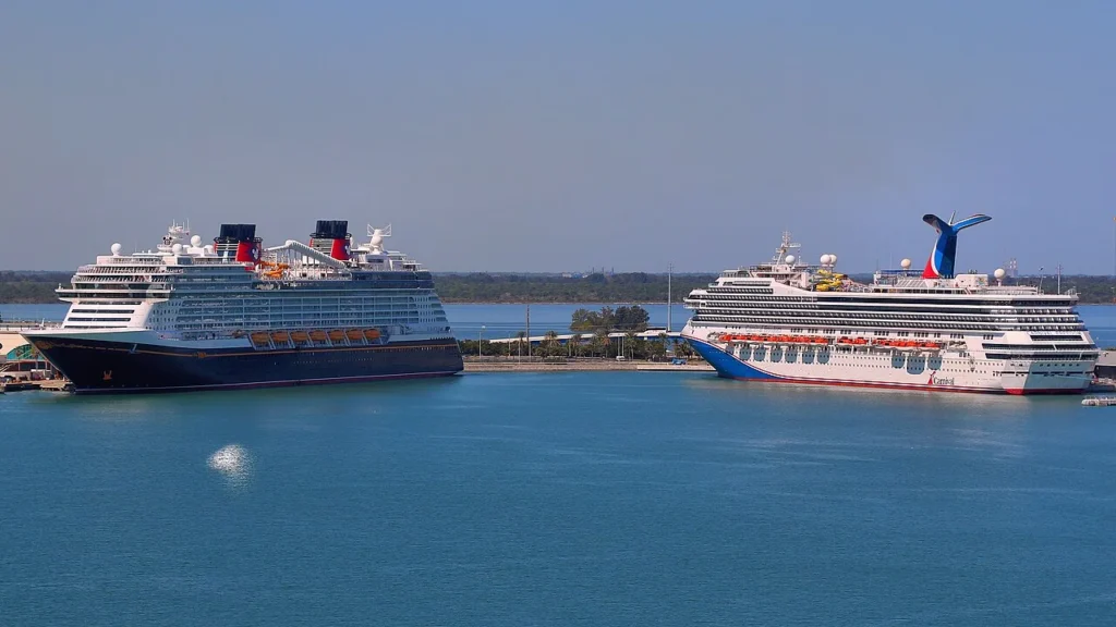 Disney Wish and Carnival Freedom cruise ships docked side by side at Port Canaveral, Florida