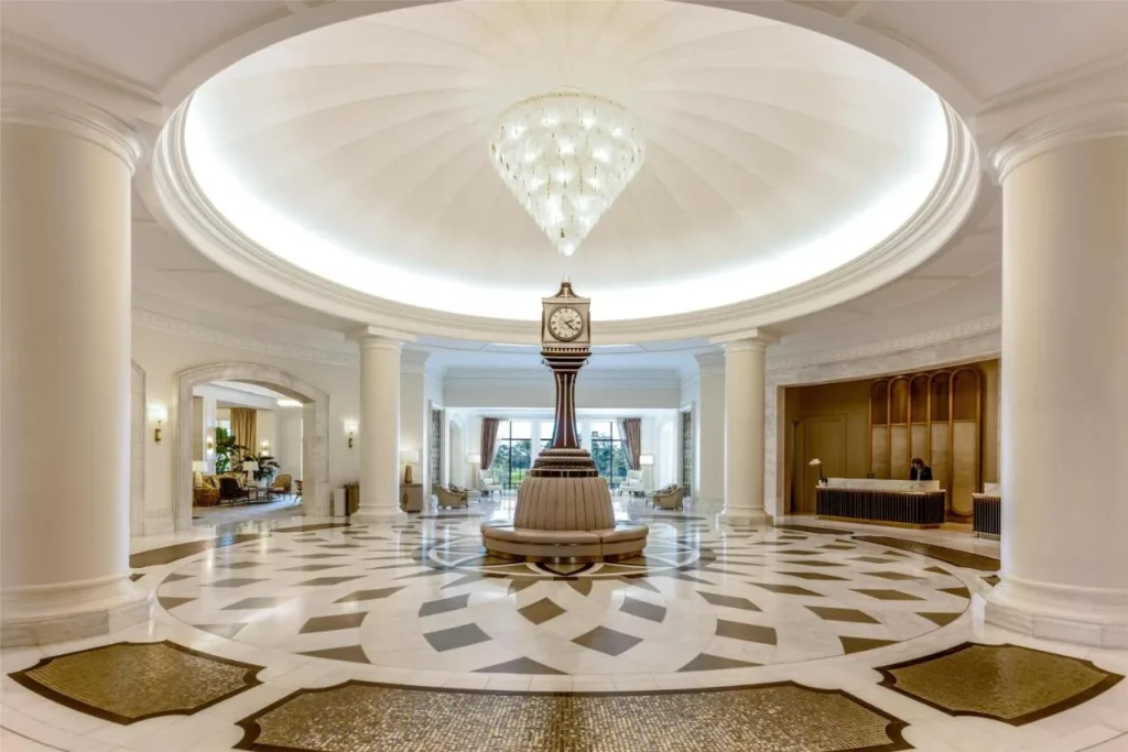 Rotonda abovedada del vestíbulo con un reloj alto, araña y piso de mármol en Waldorf Astoria Orlando