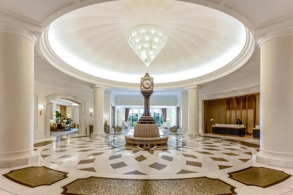 Domed lobby with a chandelier, pedestal clock and inlaid marble floor at Waldorf Astoria Orlando