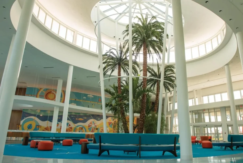 Domed lobby with palm trees and turquoise benches at Universal Cabana Bay Beach Resort