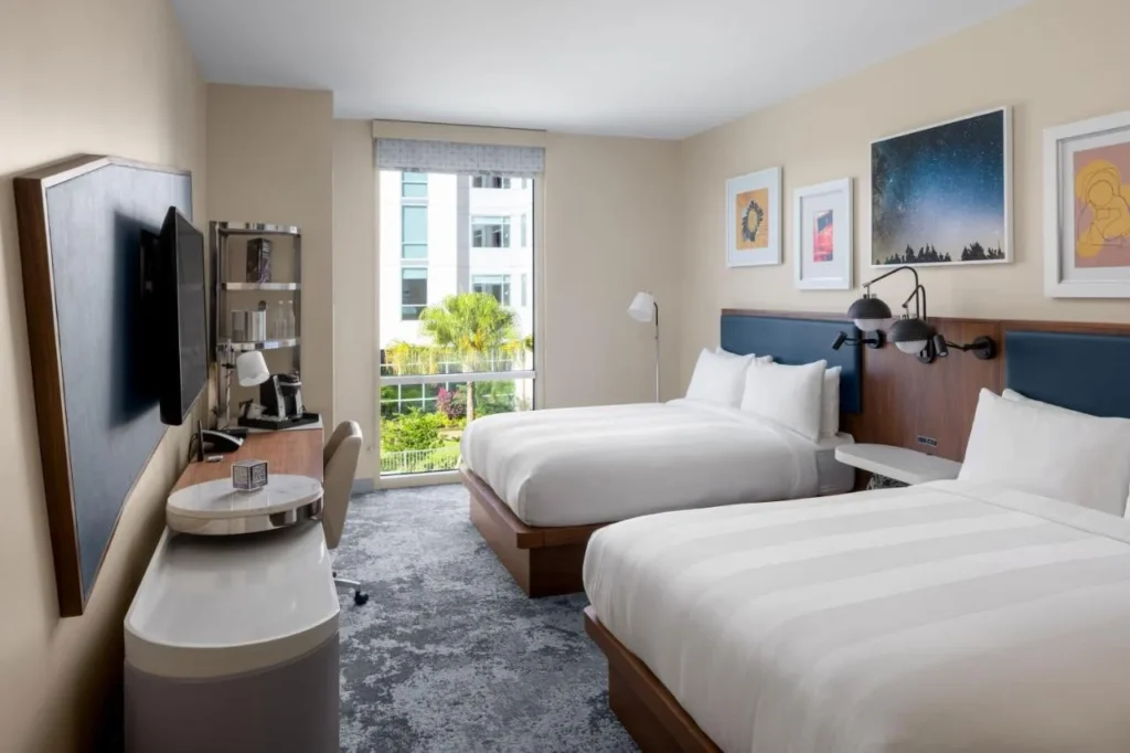 Habitaci&oacute;n doble queen en The Celeste Hotel con obras de arte con temas espaciales y una ventana alta