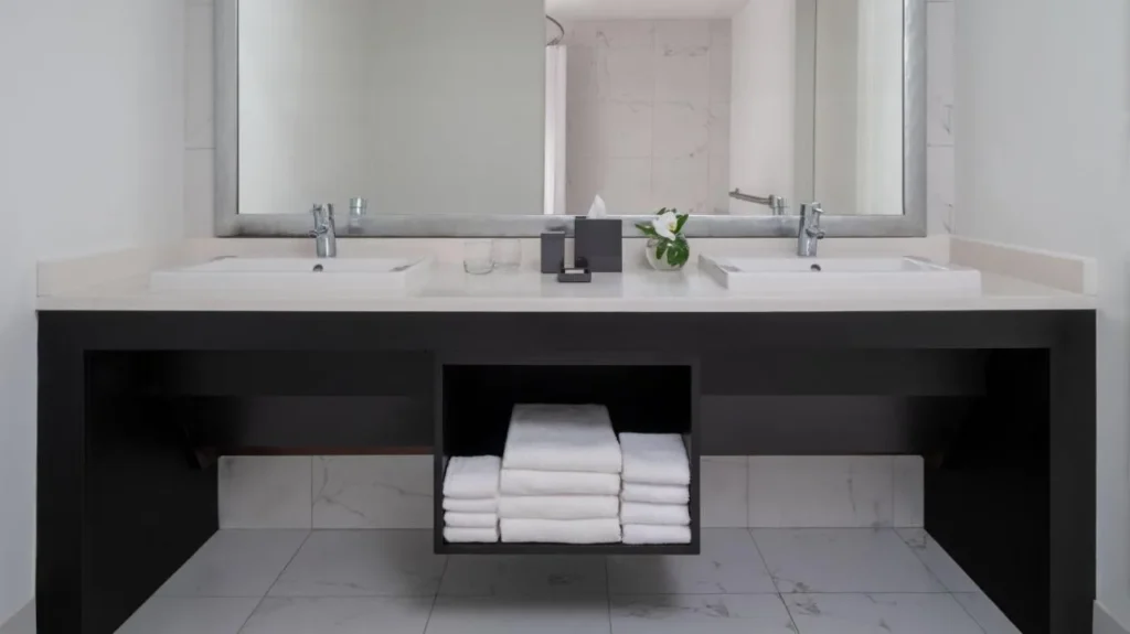 Vanidad de baño de doble fregadero con toallas blancas apiladas en Renaissance Orlando Resort and Spa