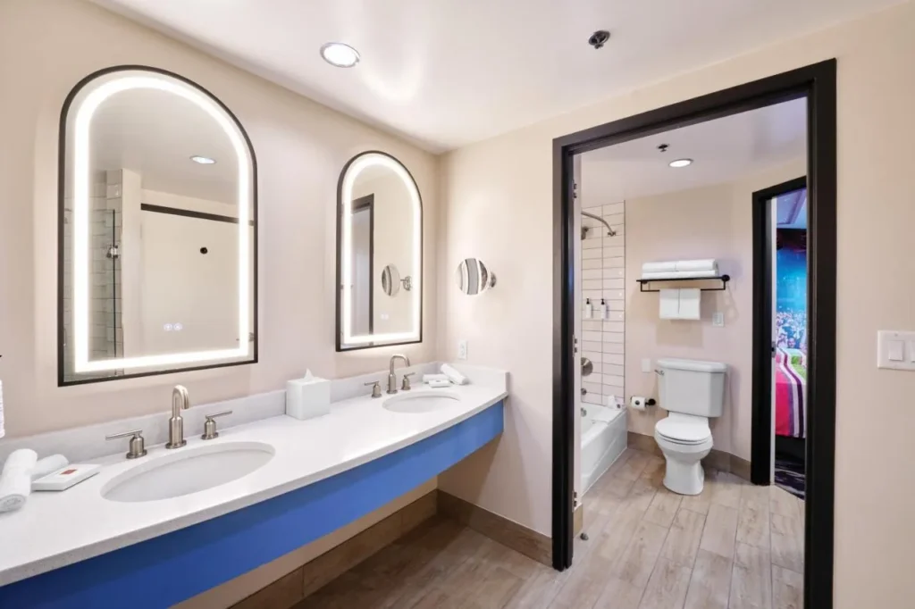 Double vanity with arched lit mirrors beside a separate tub room at Hard Rock Hotel Orlando