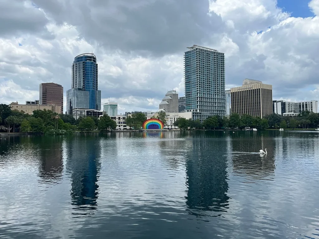 Horizonte del centro de Orlando reflejado en el Lake Eola bajo las nubes ondulantes, con el anfiteatro del arco iris