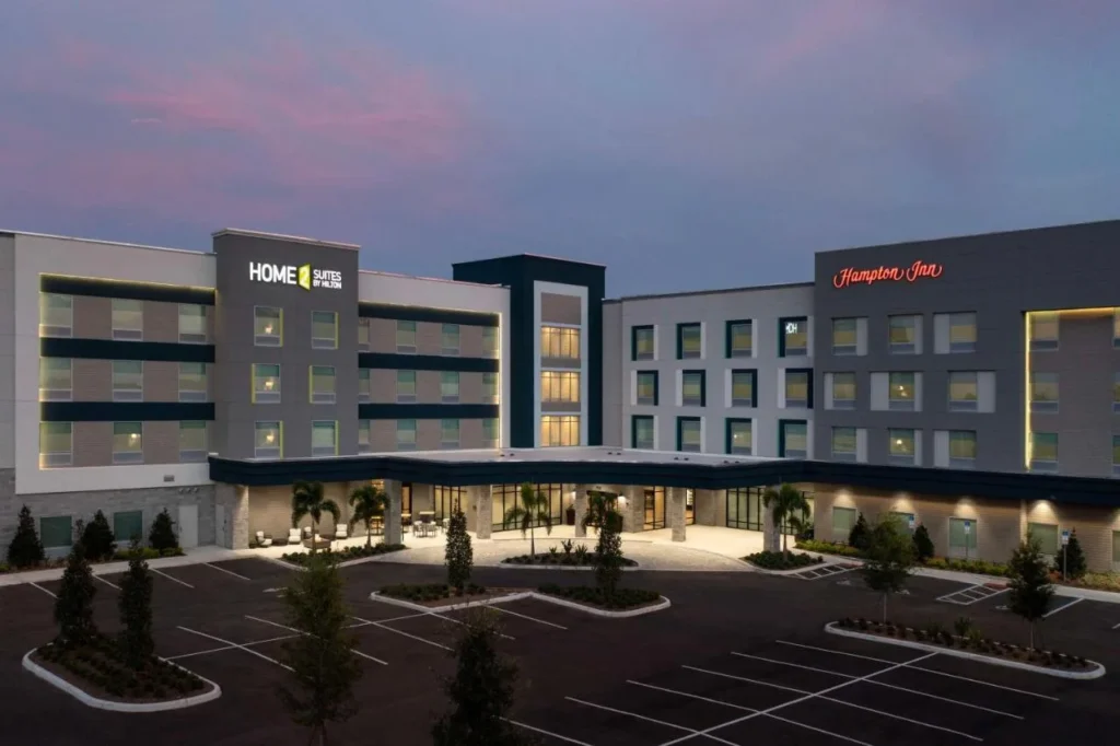 Edificio de doble marca con Hampton Inn y Home2 Suites iluminados al atardecer, Hampton Inn Southeast Nona