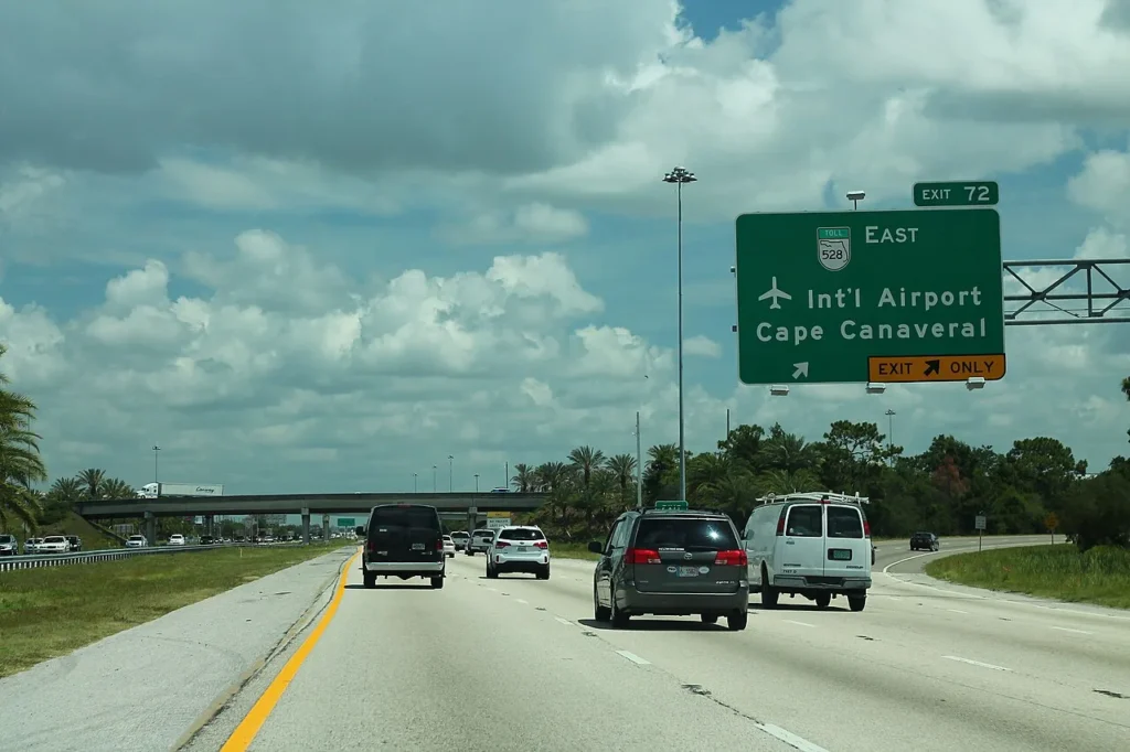 Eastbound I-4 traffic below the Exit 72 sign for toll road SR 528 toward the airport