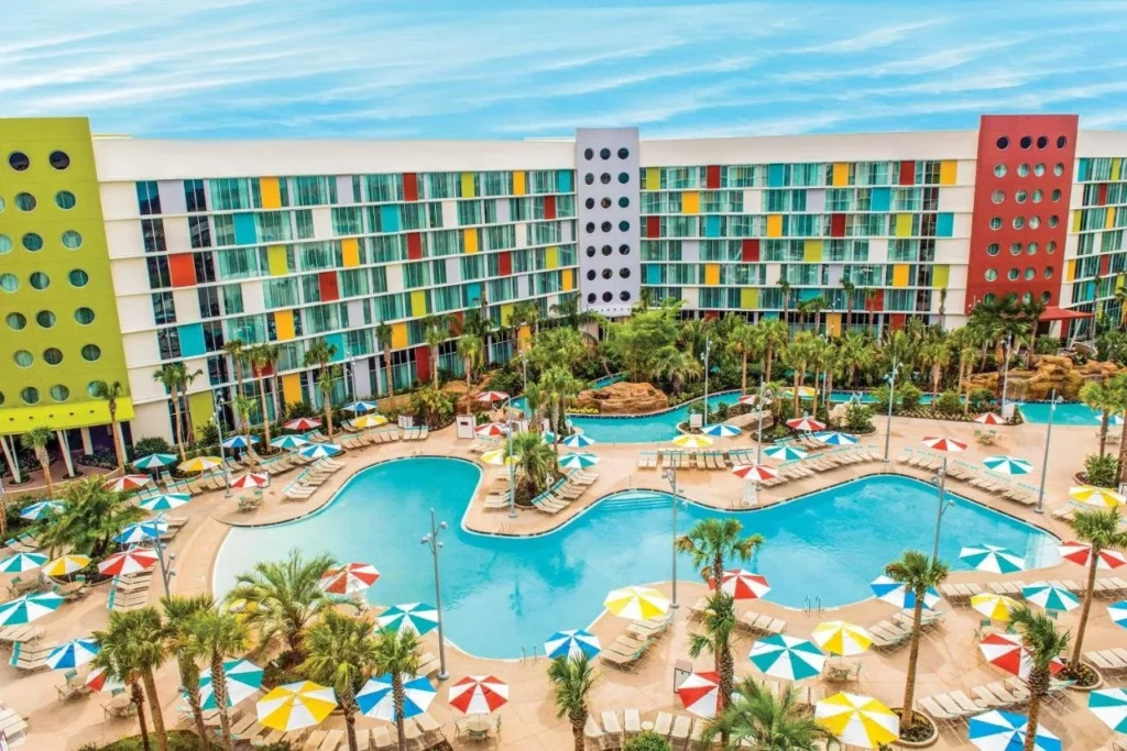 Vista elevada de una gran piscina, r&iacute;o lento y coloridos edificios retro en Universal Cabana Bay Beach Resort