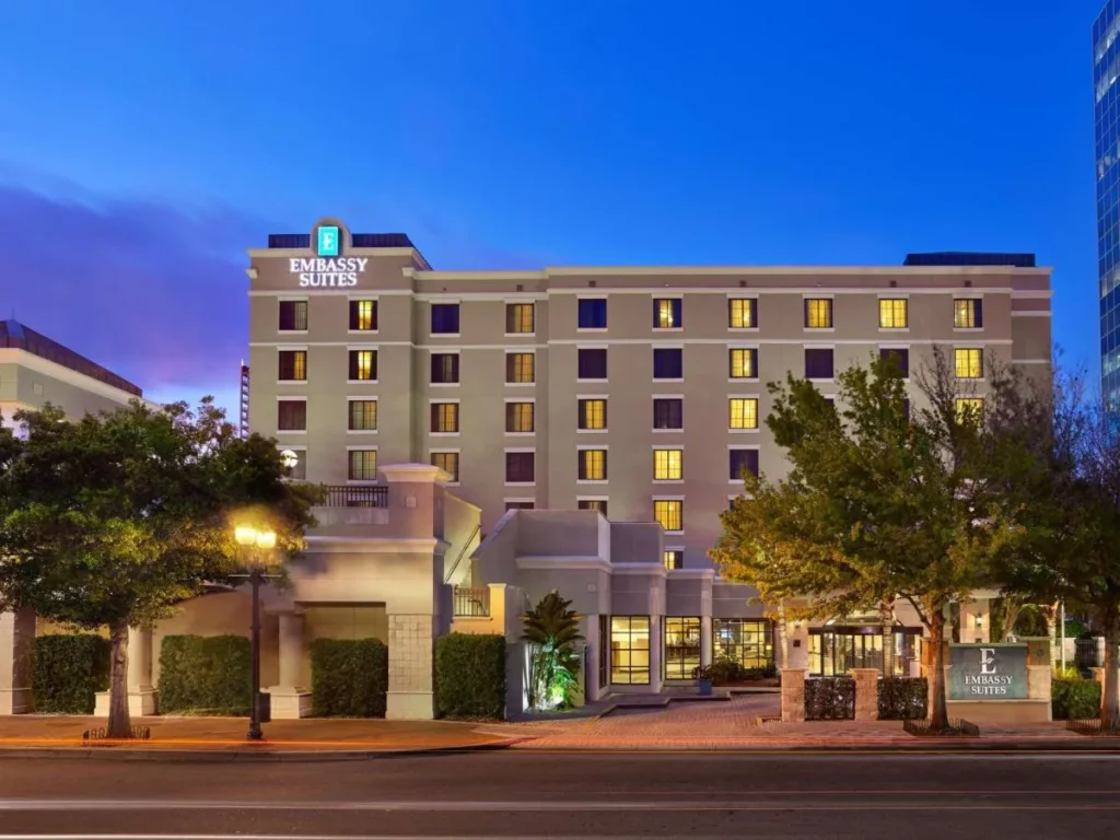 Embassy Suites by Hilton Orlando Downtown lit at dusk with its rooftop sign