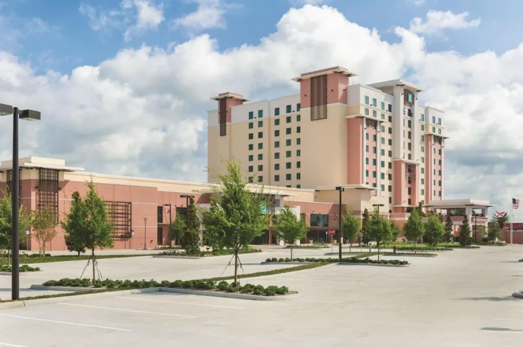 Embassy Suites Orlando Lake Buena Vista South tower behind its large open-air parking lot