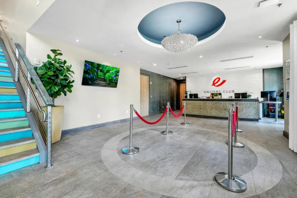 Encore Club front desk with a chandelier and colorful staircase at Encore Resort at Reunion