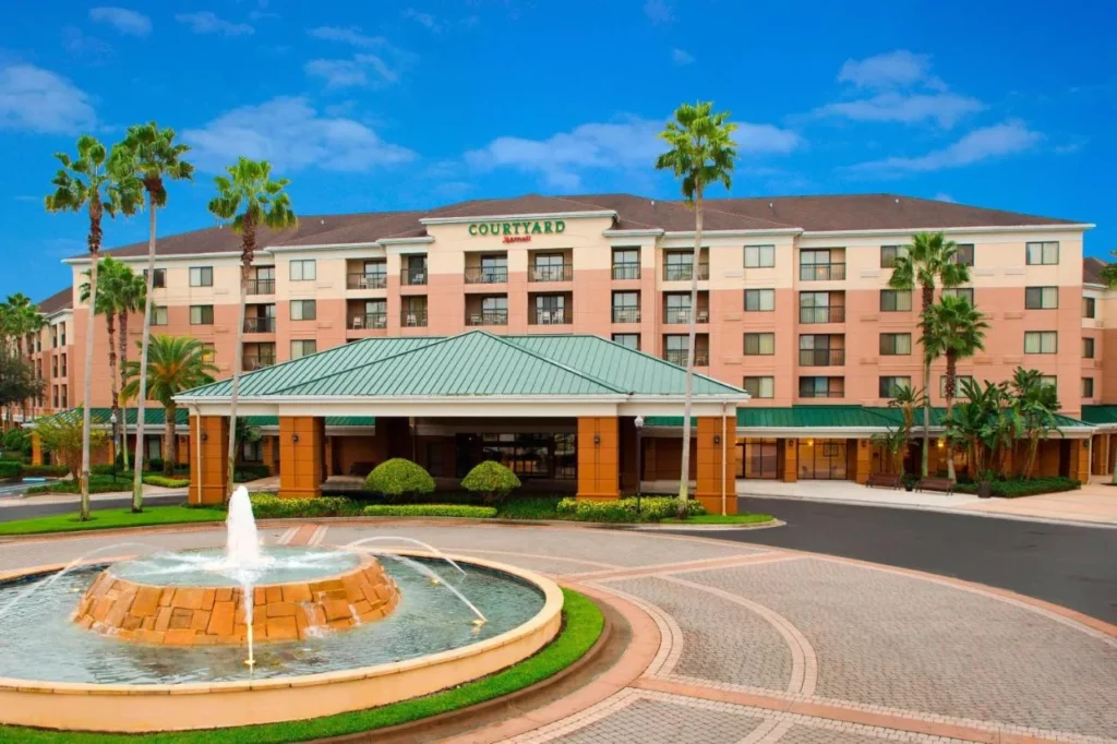 Canopy de entrada, fuente y palmeras en Courtyard Orlando Lake Buena Vista, Marriott Village