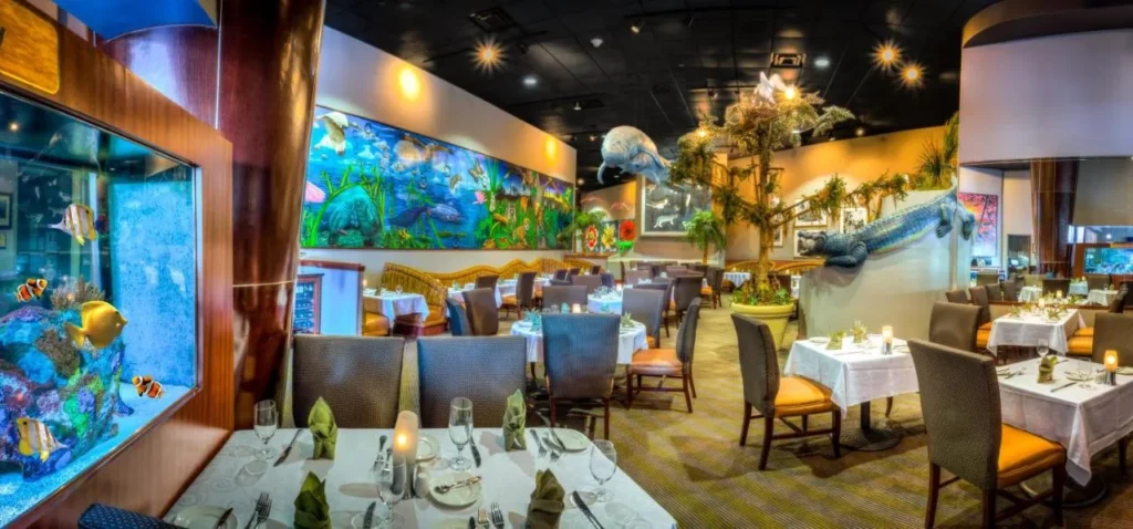Restaurante Everglades en el Rosen Centre Hotel con decoración de acuario, caimán y manatí y mesas de juego