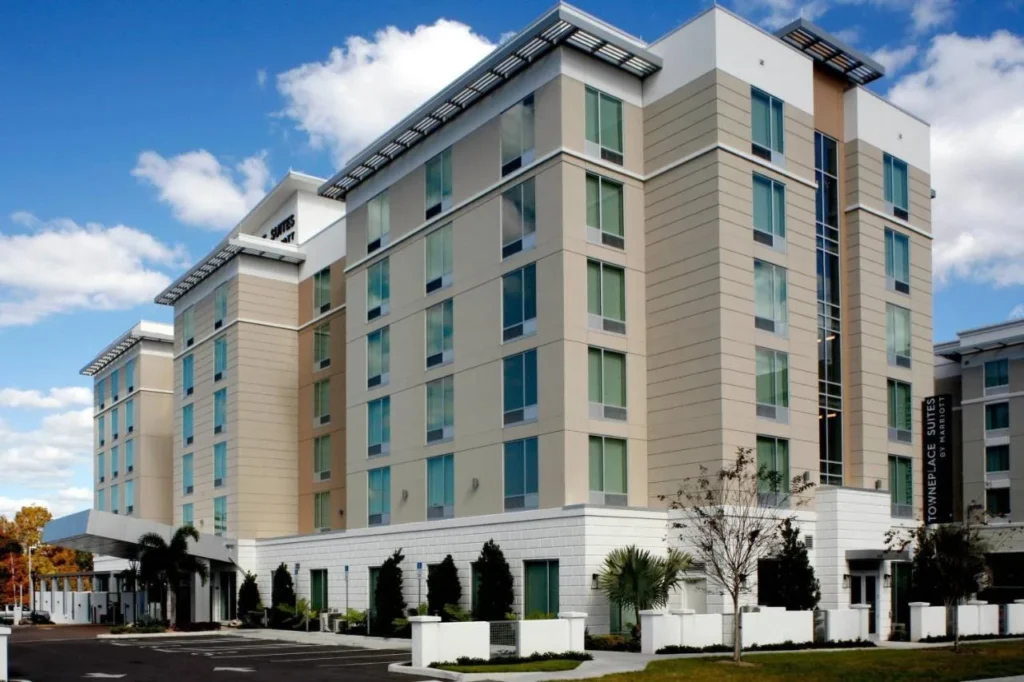 Exterior y entrada lateral de TownePlace Suites by Marriott Orlando Downtown bajo un cielo azul