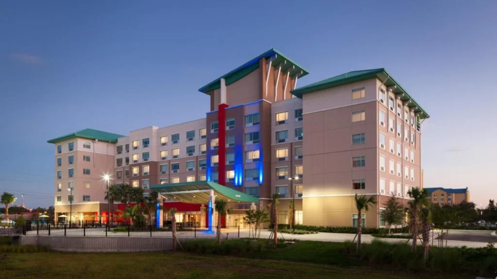 Exterior al atardecer del Holiday Inn Express & Suites Orlando at SeaWorld con su entrada iluminada