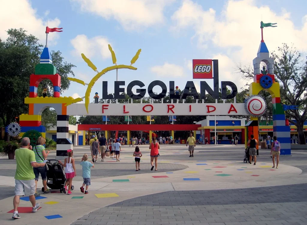 Familias caminando a través de la colorida plaza de entrada hacia el arco y las puertas de LEGOLAND Florida