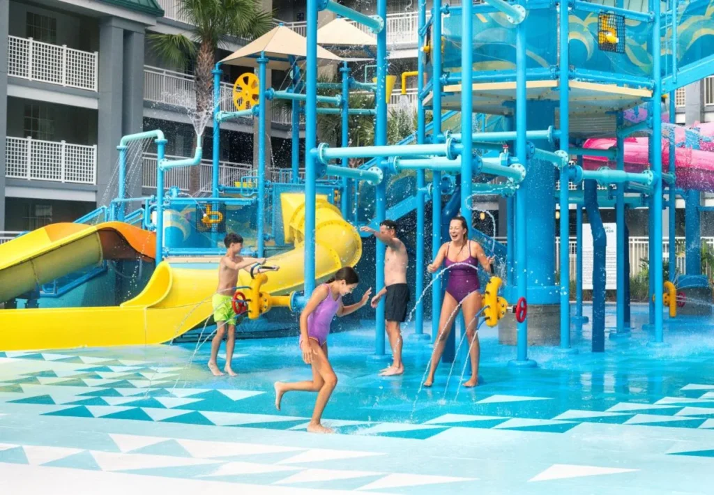 Family playing under the spray features of Aqua Cove at Holiday Inn Resort Orlando Suites