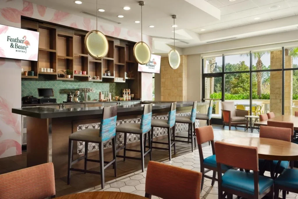 Feather & Bean Bistro barra de bar y taburetes en el vestíbulo en Home2 Suites Flamingo Crossings
