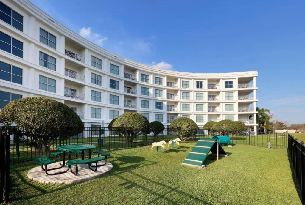 Área de juegos para perros cercada con una rampa de agilidad y mesa de picnic en Meliá Orlando Celebration