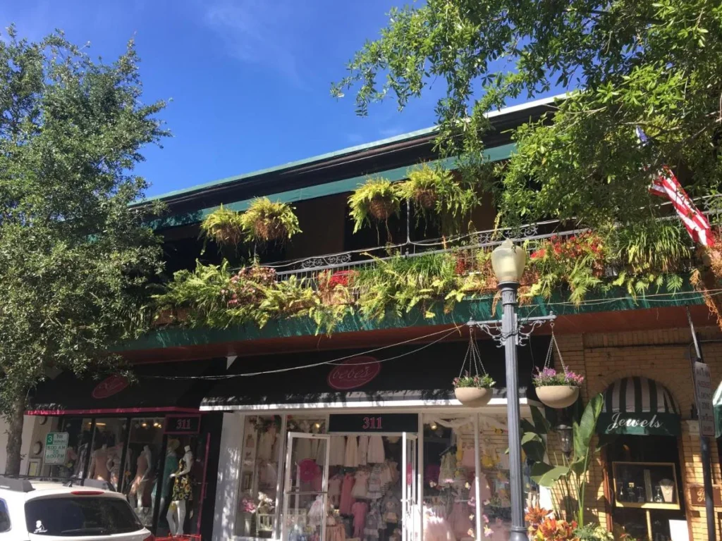 Balc&oacute;n cubierto con helechos del Park Plaza Hotel sobre las boutiques en Park Avenue en Winter Park