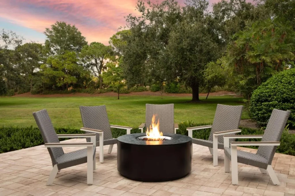 Piscina de fuego con tumbonas en un patio de c&eacute;sped en DoubleTree Suites Disney Springs