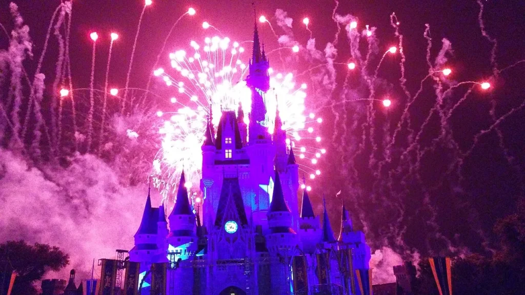 Fireworks bursting above a purple-lit Cinderella Castle during a 2014 nighttime show at Magic Kingdom