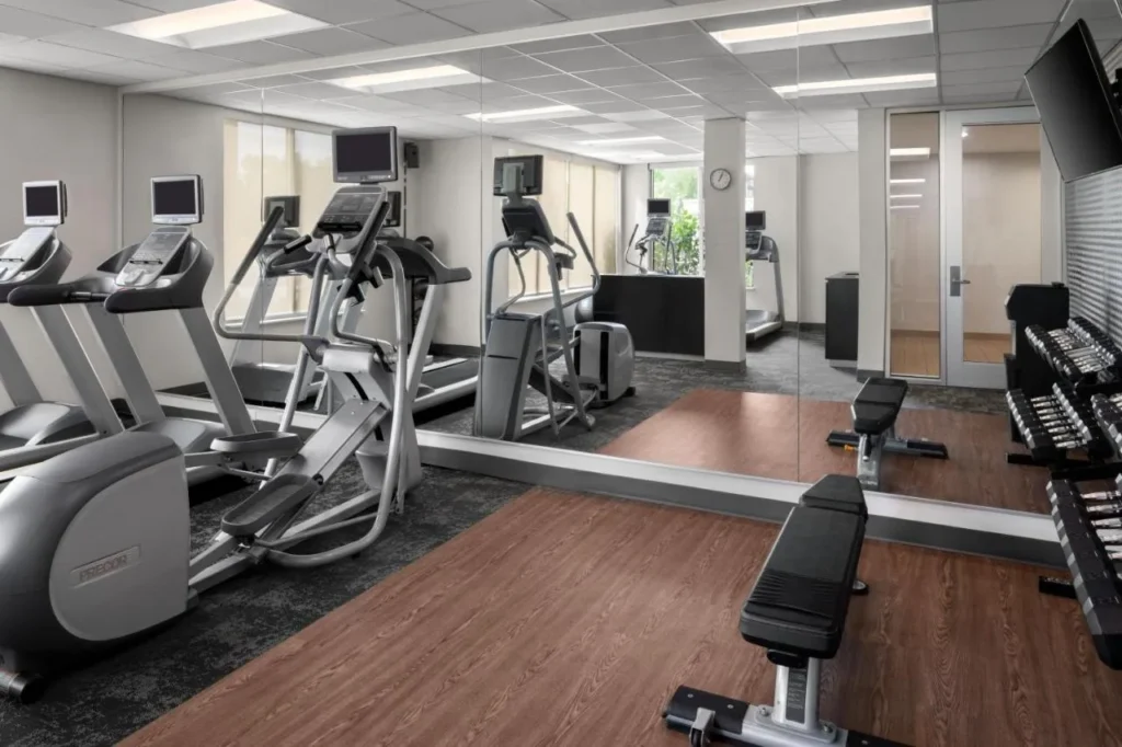 Gimnasio con cintas de correr, máquinas elípticas, un banco y mancuernas en Fairfield Inn & Suites Kissimmee / Celebration