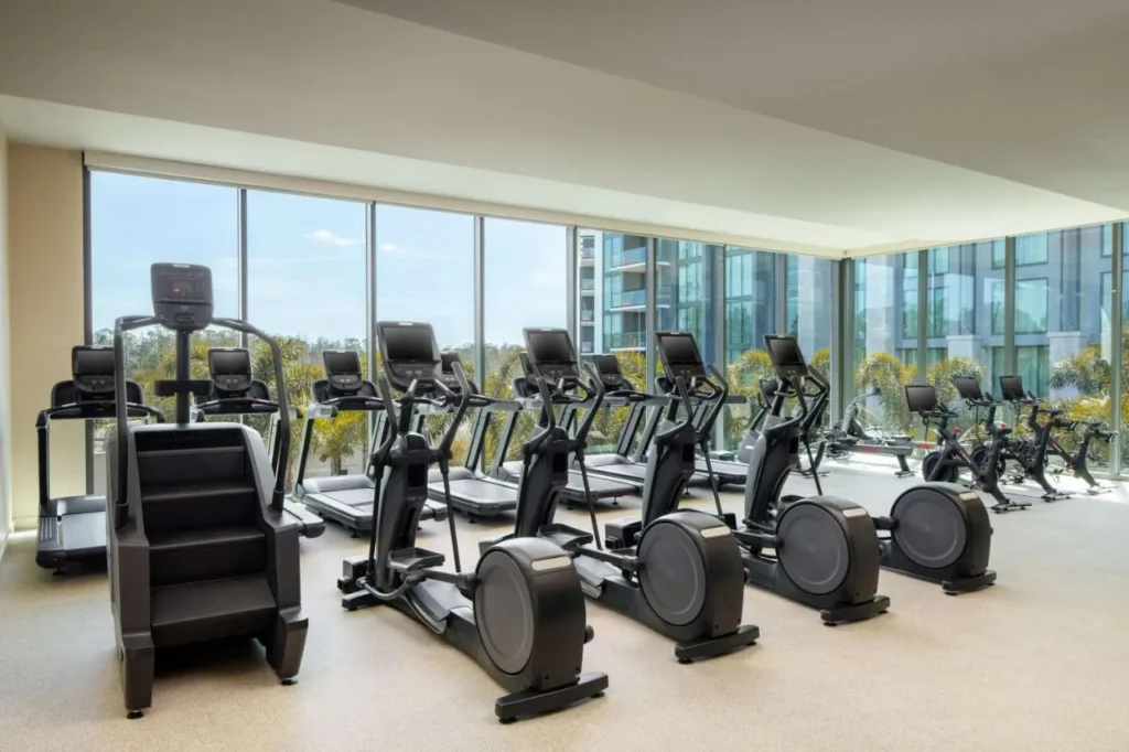 Gimnasio con cintas de correr, entrenadores el&iacute;pticos y ventanas de piso a techo en Conrad Orlando