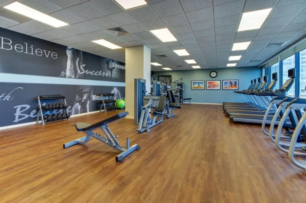 Gimnasio con cintas de correr, elípticas, máquinas de pesas y mancuernas en Drury Plaza Hotel Orlando