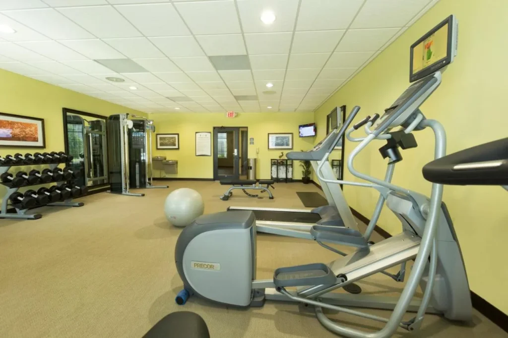 Sala de fitness con máquina elíptica, cinta de correr, pesas y soporte para mancuernas en Staybridge Suites Orlando at SeaWorld